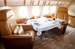 Luxury seating on private airplane, complete with table set for a meal.