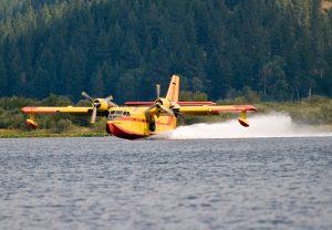 Water Scooper aircraft skimming lake to refill its water tank