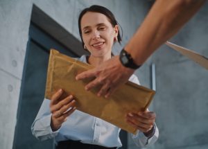 Hand Carry Service envelope being handed to recipient