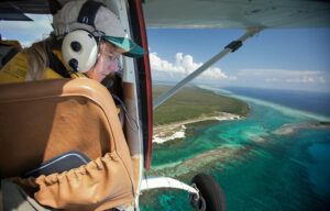 Pilot flying over environmental shoreline