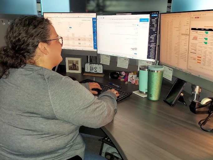 Grand Aire logistics specialist at desk working on air charter qupte