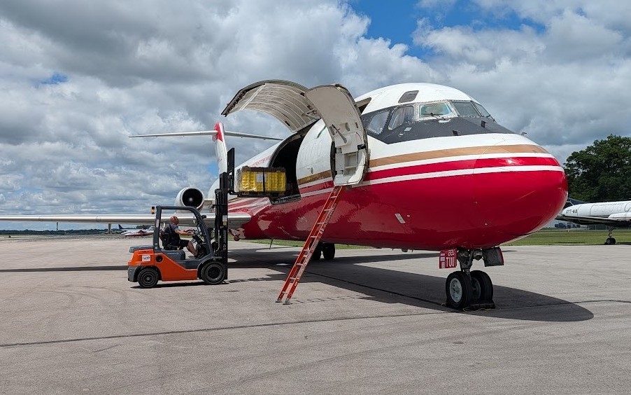 Perishable goods being loaded by forklift onto aircraft.